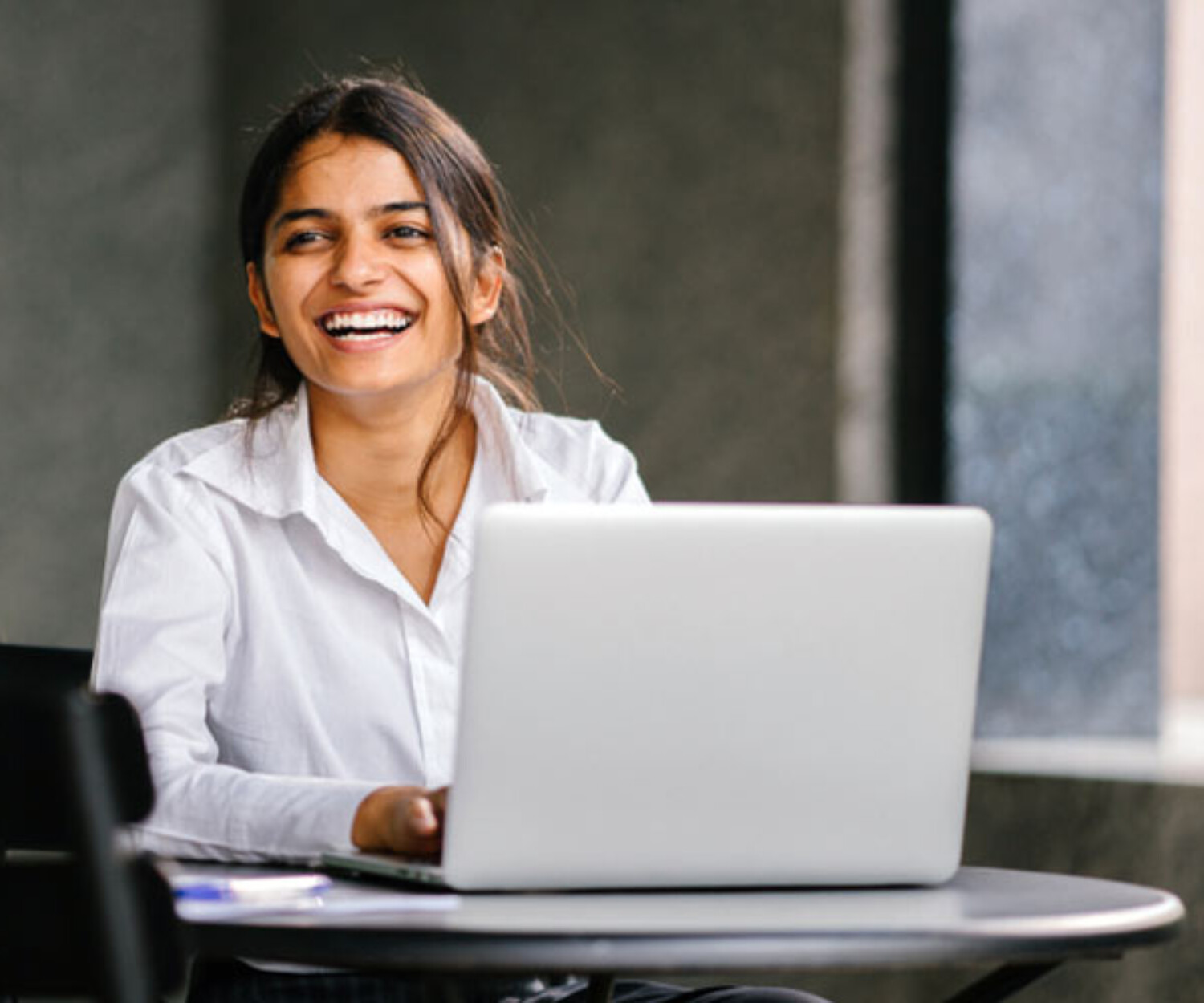 Laughing woman with laptop