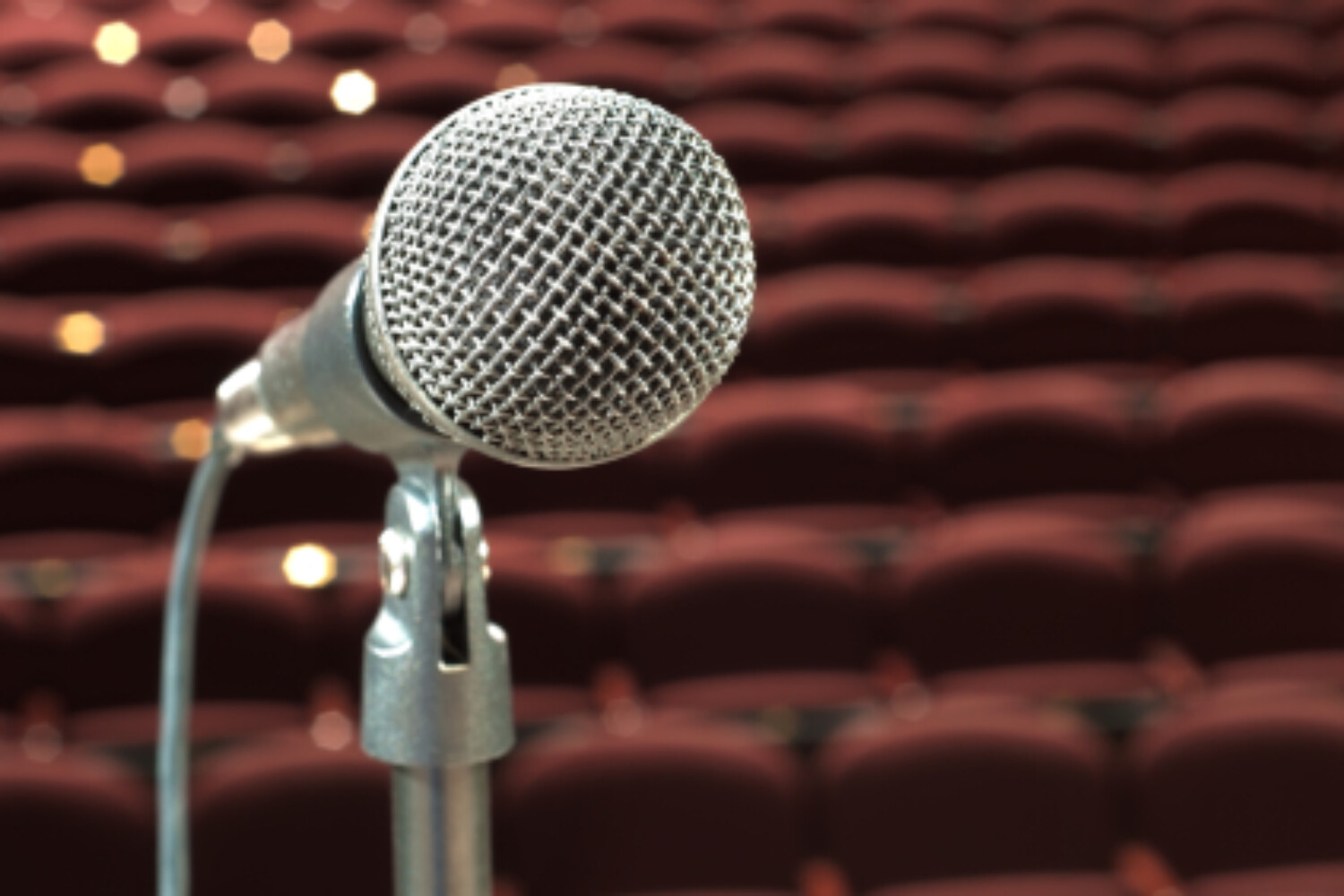 Microphone on stage with empty seats - fake microphone exercise improves vocal clarity and accent reduction
