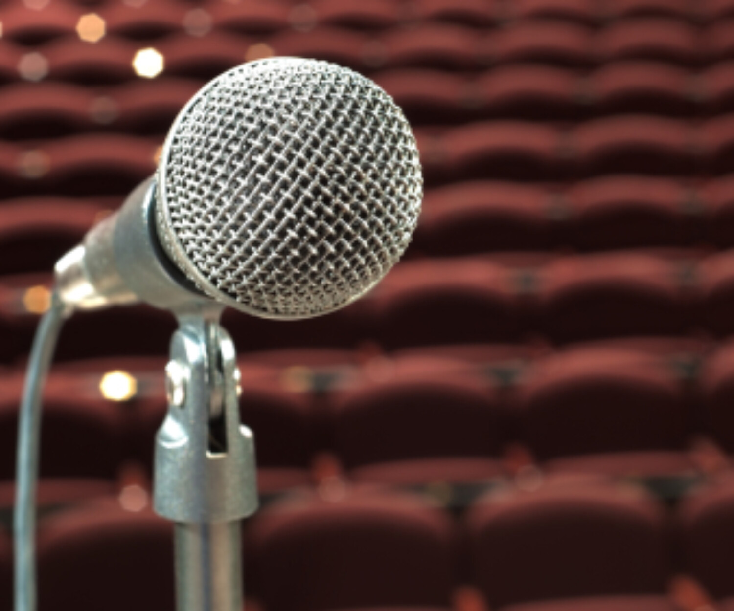 Microphone on stage with empty seats - fake microphone exercise improves vocal clarity and accent reduction